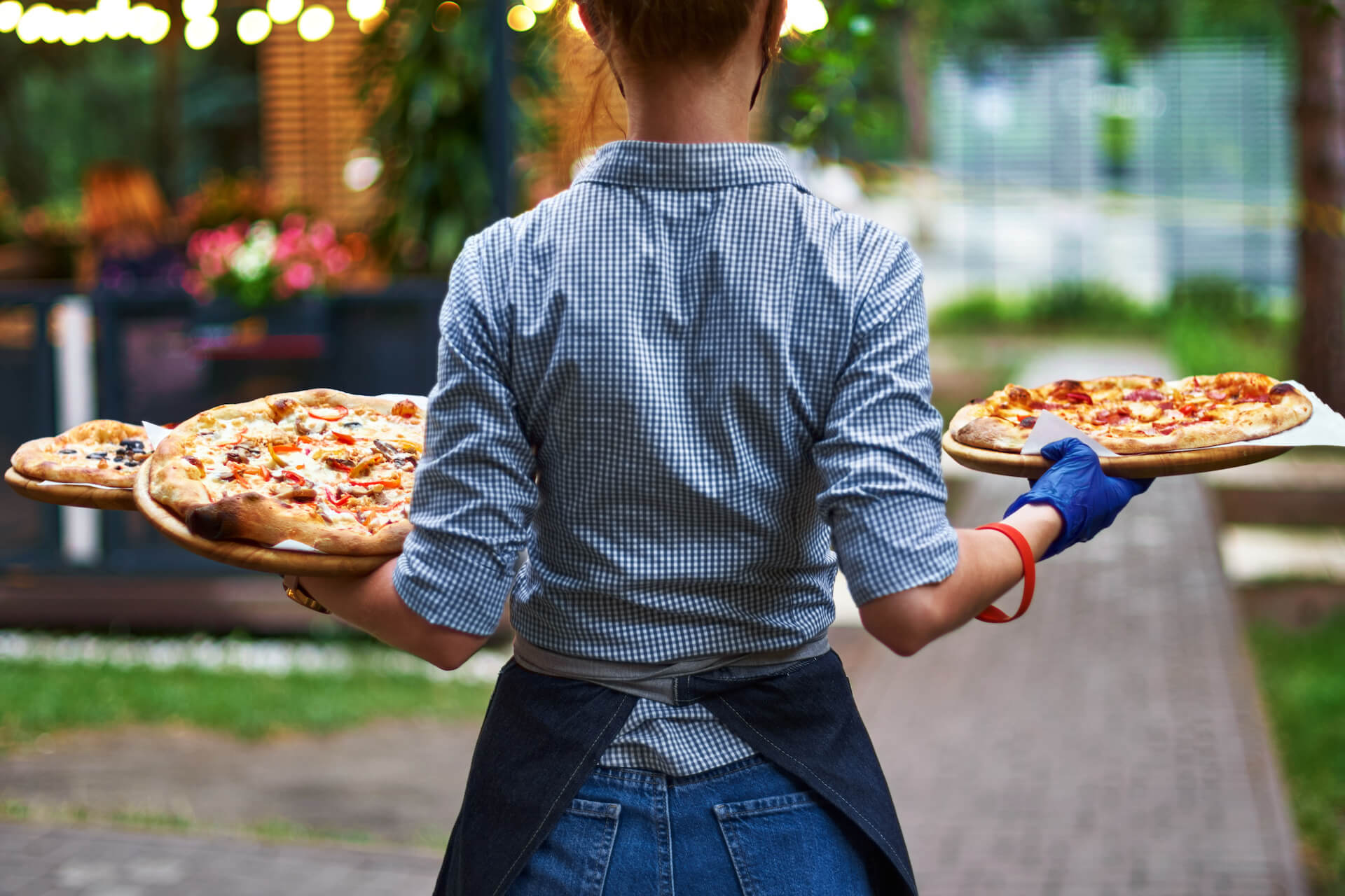 Kellnerin serviert zwei Teller mit Essen in einem Restaurant voller Gäste.